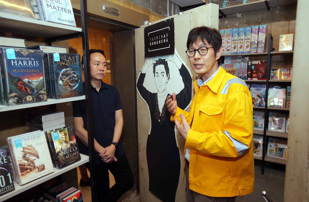 Advertising agency Leo Burnett creative group head Jovian Lee (in yellow) briefing those at the launch of the bookstore about the Yasmin at Kong Heng Newseum. — Picture by Farhan Najib